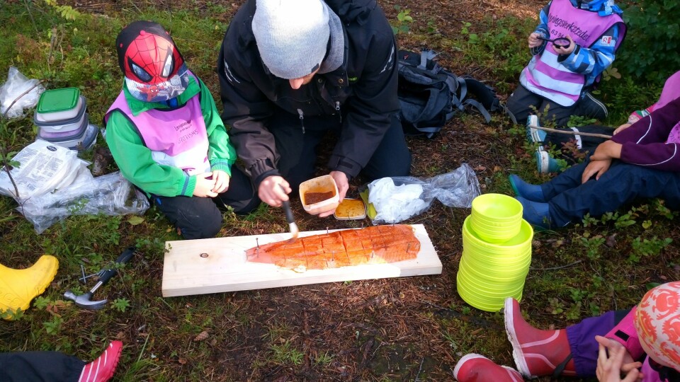 Barna og pedagogisk leder Alexander Kringstad Aanes i Læringsverkstedet Hammersborg barnehage tilbereder laks som skal stekes på bålet.