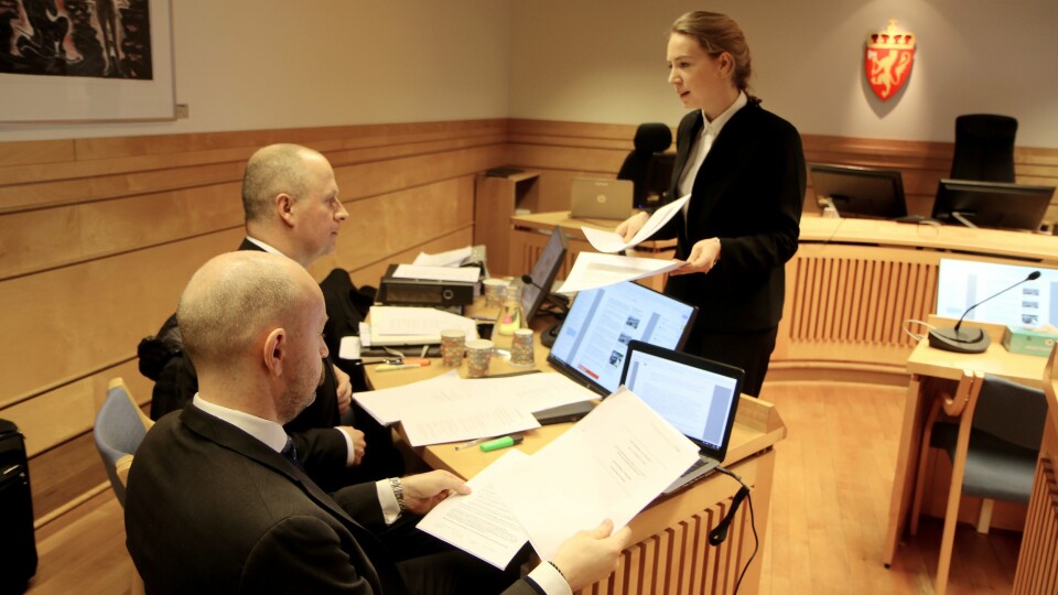 Advokatfullmektig Hanne Inger Bjurstrøm Jahren fra Regjeringsadvokaten deler ut sakspapirer til motparten. Til venstre partshjelper for Gnist Trøa, advokat Einar Brunes fra PBL.