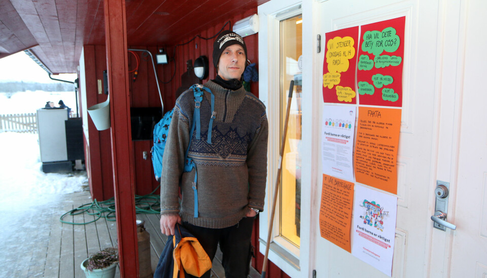 Raymond Hansen foran inngangen til barnehagen, prydet med infoplakater om saken.