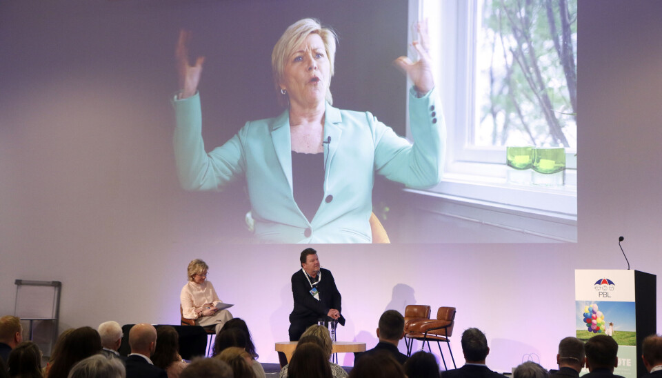 Øystein Djupedal i samtale med Trude Teide under landsmøtet til PBL, Siv Jensen på storskjerm.