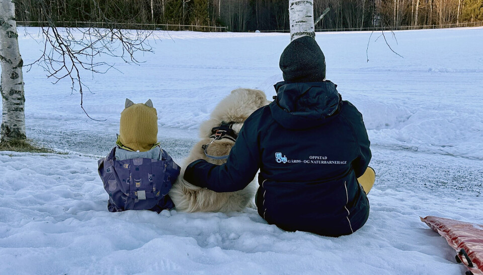 Oppstad gårds- og naturbarnehage ligger på Skarnes i Sør-Odal kommune. Bilde av barn, ansatt og ansatt sin hund. Denne hunden eies av den ansatte, men har vært med daglig i barnehagen fra valpetiden og er en del av hverdagen til barna.